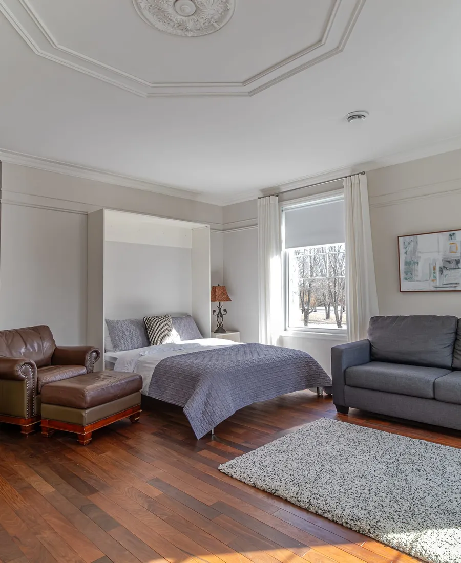 Studio avec fauteuil en cuir et ottoman